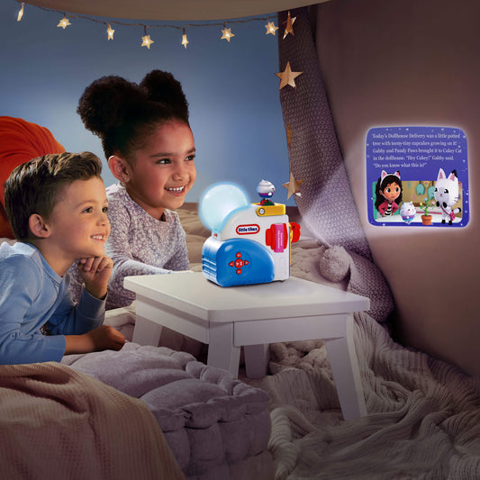 Two children sitting in a cozy bed-like room, looking at a small toy projector on a white table that casts a glowing light and story text onto a wall.