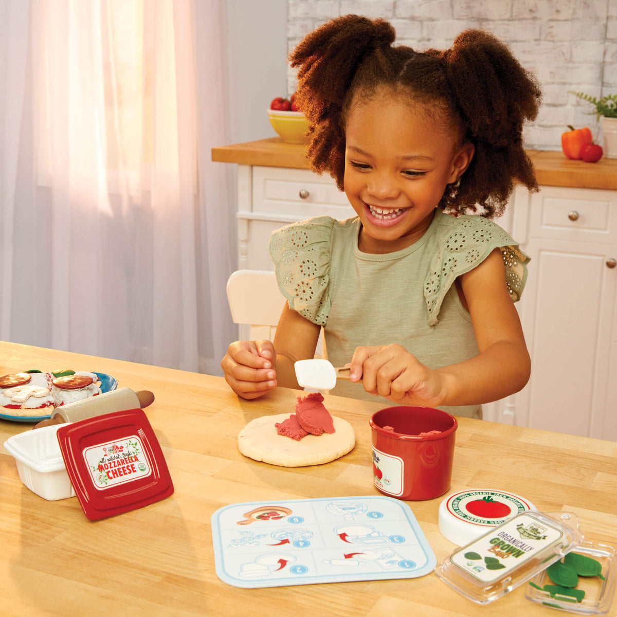 Girl adding pizza sauce to dough