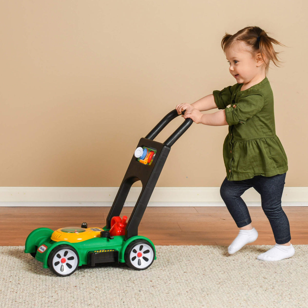 Girl pushing lawn mower inside