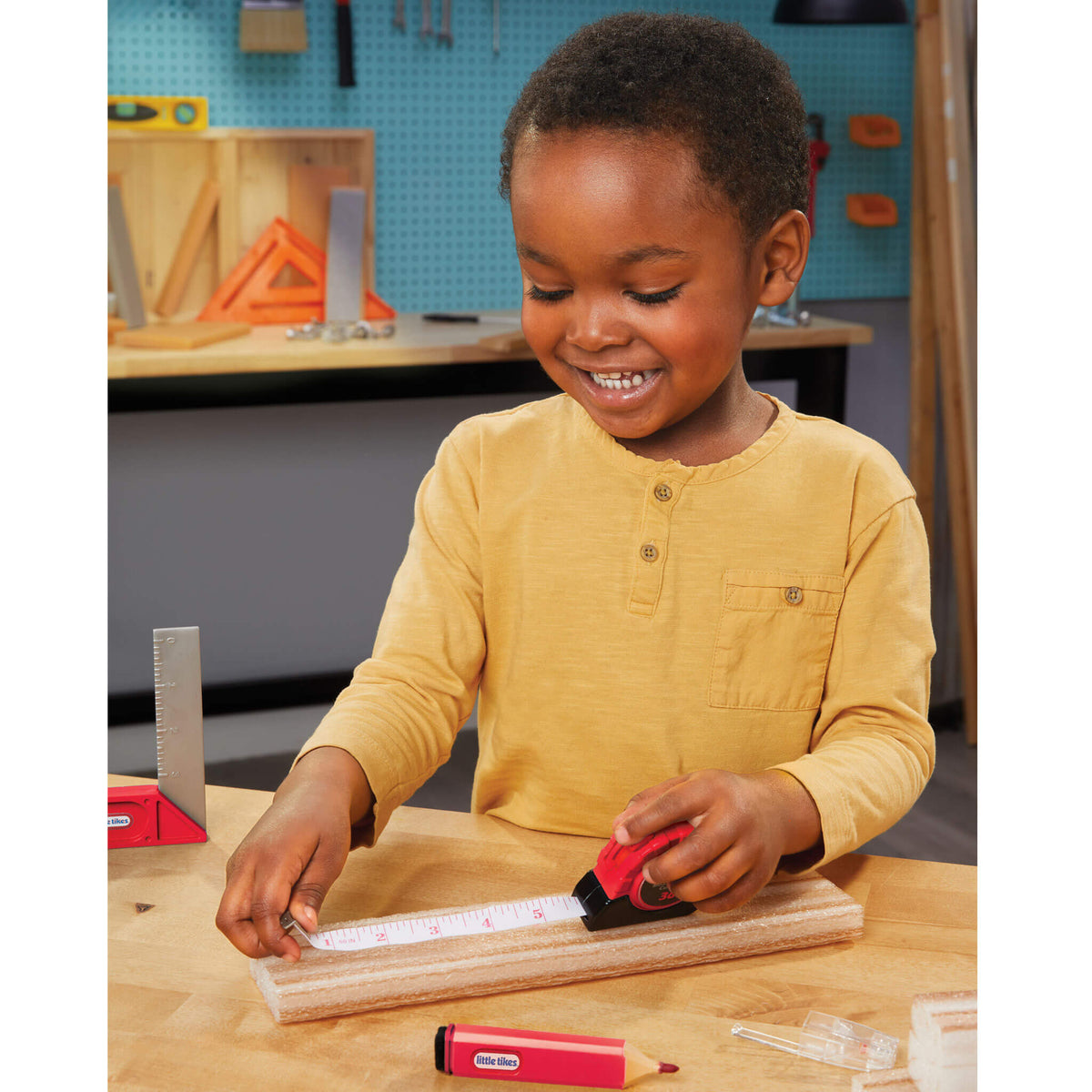 Boy measuring with a toy tape measure